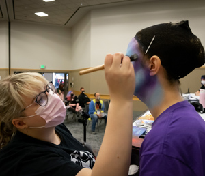 Cosplayers applying makeup