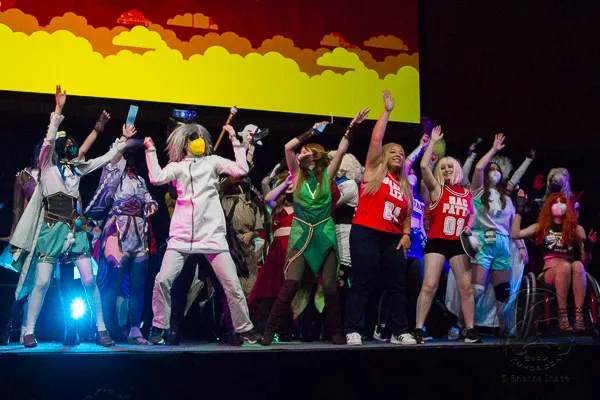 A large group of Lip Sync Showdown participants and staff celebrating together on stage.