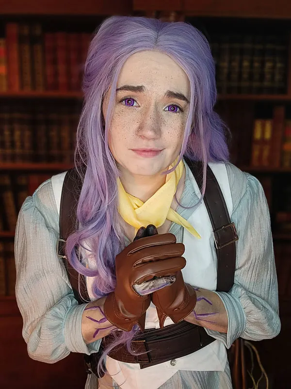 Portrait of Momma Sammu in a light-colored costume with purple hair.