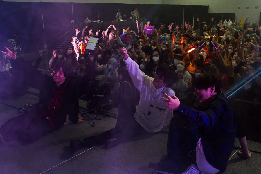 Guests posing with a large crowd of fans